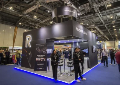 A stunning exhibition stand for Revolut Business by a professional exhibition stand builder and contractor at Hospitality Tech Expo 2024, showcasing modern black design and branded elements.